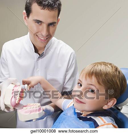 Boy learning how to brush teeth with the help of dentures in a dentist's office View Large Photo Image Stock Photo - Boy learning how to brush teeth with the help of dentures in a dentist's office. Fotosearch