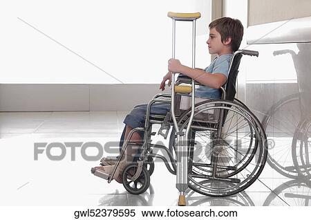 Boy sitting in a wheelchair View Large Photo Image Stock Photography - Boy sitting in a wheelchair. Fotosearch