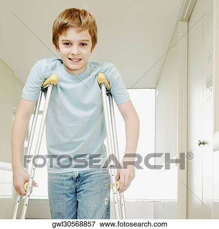 Boy standing with crutches and smiling View Large Photo Image Stock Photo - Boy standing with crutches and smiling. Fotosearch
