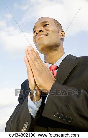 Stock Image - Businessman in prayer position. Fotosearch