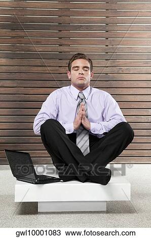 Businessman meditating near a laptop View Large Photo Image Stock Image - Businessman meditating near a laptop. Fotosearch