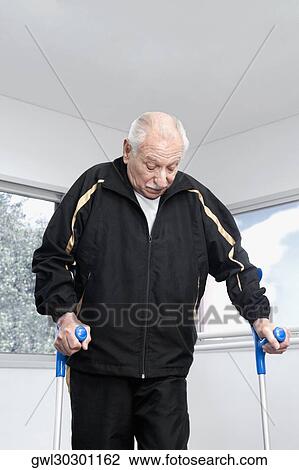 Close-up of a disabled man walking with crutches View Large Photo Image Stock Image - Close-up of a disabled man walking with crutches. Fotosearch