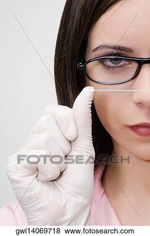 Close-up of a female dentist holding dental floss View Large Photo Image Stock Photo - Close-up of a female dentist holding dental floss. Fotosearch