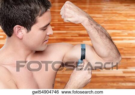 Close-up of a man measuring his biceps with a tape measure View Large Photo Image Stock Photograph - Close-up of a man measuring his biceps with a tape measure. Fotosearch