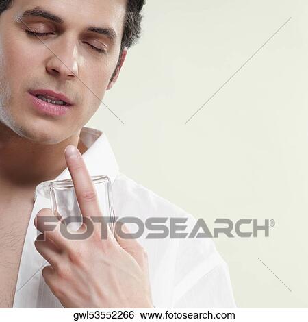 Close-up of a man smelling perfume View Large Photo Image Stock Photograph - Close-up of a man smelling perfume. Fotosearch