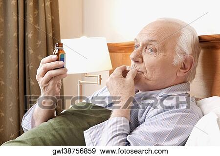 Close-up of a man taking medicine View Large Photo Image Stock Photo - Close-up of a man taking medicine. Fotosearch