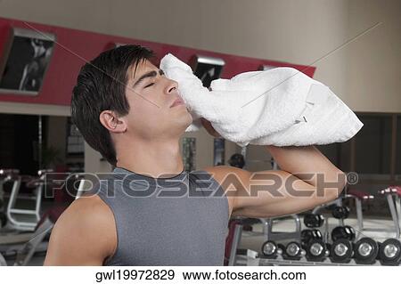 Close-up of a man wiping his face with a towel View Large Photo Image Stock Photo - Close-up of a man wiping his face with a towel. Fotosearch