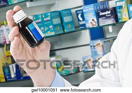 Close-up of a pharmacist's hand holding a vial of medicine View Large Photo Image Stock Image - Close-up of a pharmacist's hand holding a vial of medicine. Fotosearch
