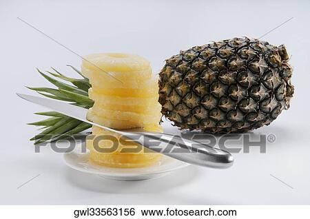 Close-up of a pineapple and pineapple slices View Large Photo Image Stock Photograph - Close-up of a pineapple and pineapple slices. Fotosearch
