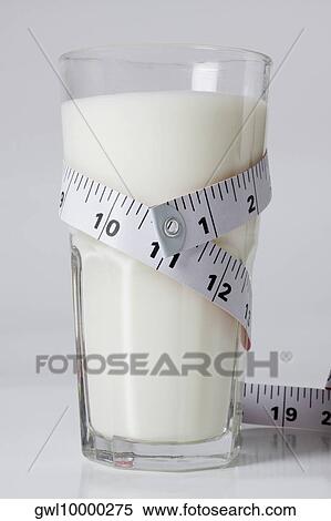 Stock Photography - Close-up of a tape measure around a glass of milk. Fotosearch