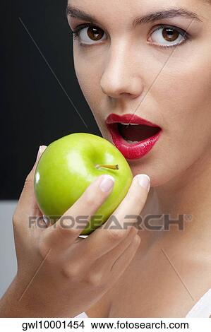 Close-up of a woman eating a granny smith apple View Large Photo Image Picture - Close-up of a woman eating a granny smith apple. Fotosearch
