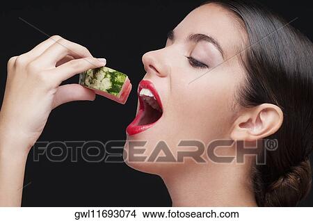 Close-up of a woman eating a watermelon slice View Large Photo Image Picture - Close-up of a woman eating a watermelon slice. Fotosearch