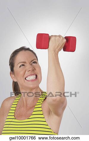 Close-up of a woman exercising with a dumbbell View Large Photo Image Stock Photograph - Close-up of a woman exercising with a dumbbell. Fotosearch