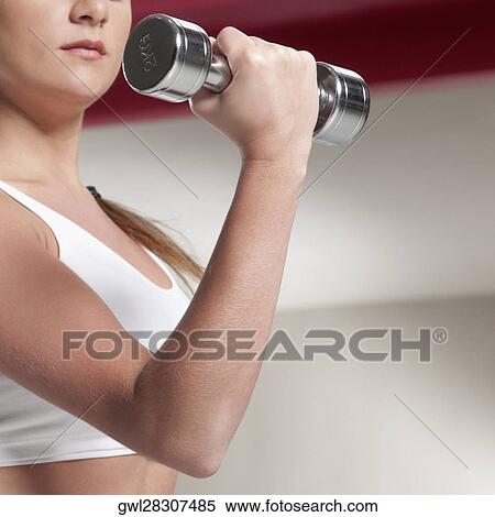 Close-up of a woman exercising with dumbbell View Large Photo Image Stock Photography - Close-up of a woman exercising with dumbbell. Fotosearch