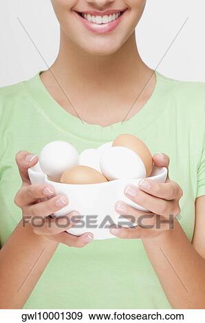 Close-up of a woman holding a bowl of eggs View Large Photo Image Stock Photo - Close-up of a woman holding a bowl of eggs . Fotosearch