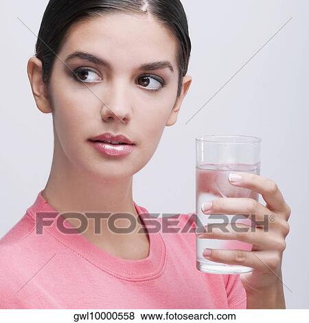 Close-up of a woman holding a glass of water View Large Photo Image Stock Photo - Close-up of a woman holding a glass of water. Fotosearch