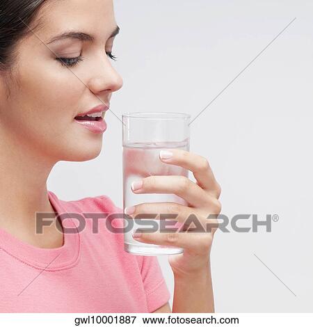 Close-up of a woman holding a glass of water View Large Photo Image Stock Photo - Close-up of a woman holding a glass of water. Fotosearch