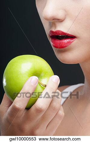 Close-up of a woman holding a granny smith apple View Large Photo Image Stock Image - Close-up of a woman holding a granny smith apple. Fotosearch