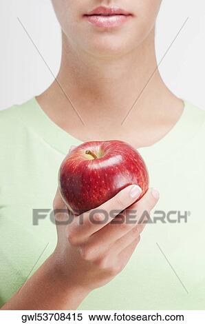 Close-up of a woman holding a red apple View Large Photo Image Stock Photography - Close-up of a woman holding a red apple. Fotosearch