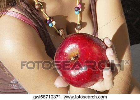 Close-up of a woman holding an apple View Large Photo Image Stock Image - Close-up of a woman holding an apple. Fotosearch