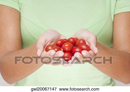 Close-up of a woman holding cherry tomatoes View Large Photo Image Stock Photo - Close-up of a woman holding cherry tomatoes. Fotosearch