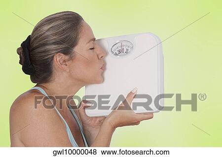Close-up of a woman kissing a bathroom scale View Large Photo Image Stock Photo - Close-up of a woman kissing a bathroom scale. Fotosearch