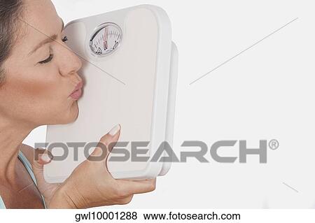 Close-up of a woman kissing a bathroom scale View Large Photo Image Stock Photo - Close-up of a woman kissing a bathroom scale. Fotosearch
