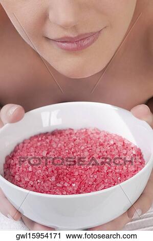 Stock Image - Close-up of a woman lying on a massage table and smelling a bowl of bath salt. Fotosearch