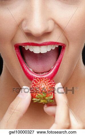 Close-up of a woman putting a strawberry in her mouth View Large Photo Image Stock Photo - Close-up of a woman putting a strawberry in her mouth. Fotosearch