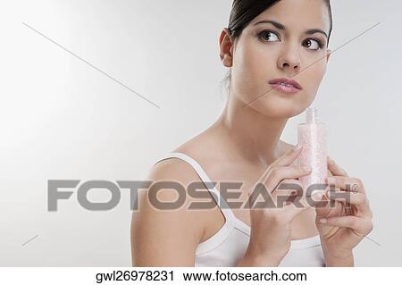 Stock Image - Close-up of a woman smelling moisturizer cream. Fotosearch