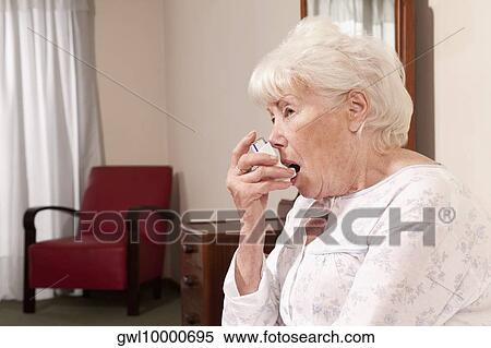 Close-up of a woman using inhaler View Large Photo Image Stock Photography - Close-up of a woman using inhaler. Fotosearch