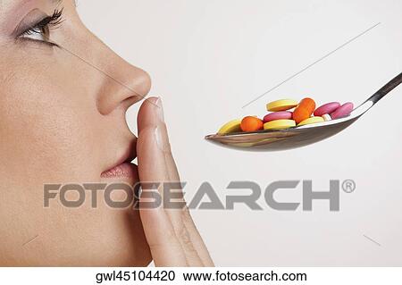 Close-up of a woman with a spoonful of pills View Large Photo Image Stock Image - Close-up of a woman with a spoonful of pills. Fotosearch