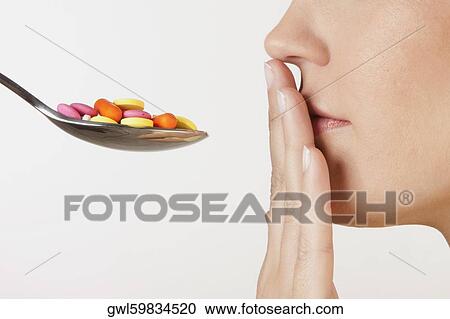 Close-up of a woman with a spoonful of pills View Large Photo Image Stock Image - Close-up of a woman with a spoonful of pills. Fotosearch