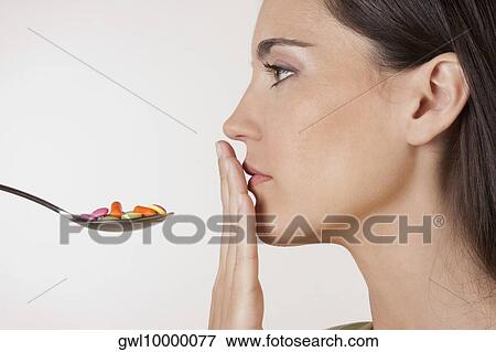 Close-up of a woman with a spoonful of pills View Large Photo Image Stock Photo - Close-up of a woman with a spoonful of pills. Fotosearch