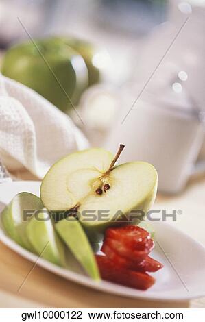 Stock Image - Close-up of apple and strawberry slices on a plate. Fotosearch