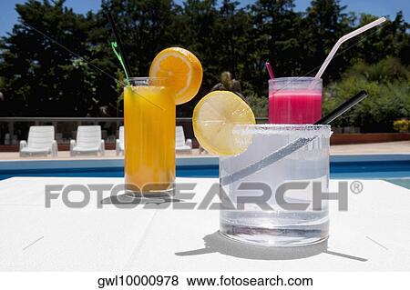 Stock Photo - Close-up of assorted drinks at the poolside. Fotosearch