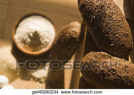 Close-up of breads with a bowl of flour View Large Photo Image Picture - Close-up of breads with a bowl of flour. Fotosearch