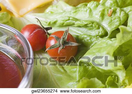 Picture - Close-up of cherry tomatoes on lettuce. Fotosearch