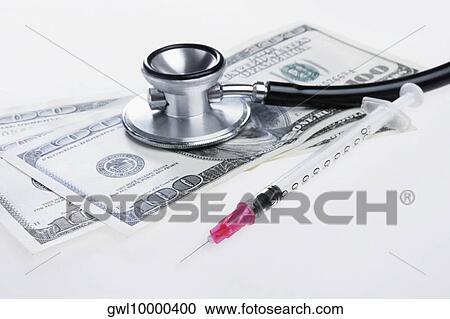 Stock Image - Close-up of hundred dollar bills with a stethoscope and a syringe. Fotosearch