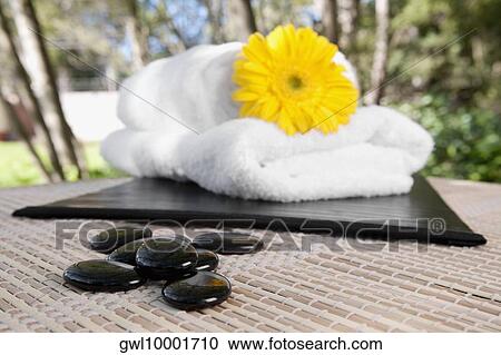 Close-up of towels with a flower and pebbles View Large Photo Image Stock Image - Close-up of towels with a flower and pebbles. Fotosearch