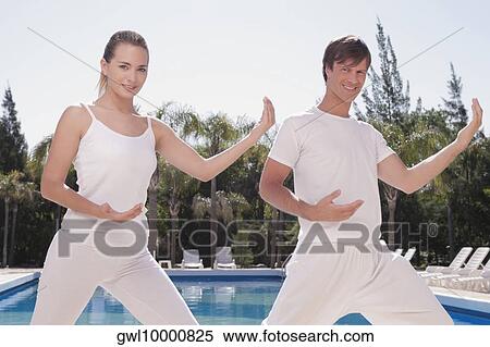 Couple exercising at the poolside View Large Photo Image Stock Photography - Couple exercising at the poolside. Fotosearch