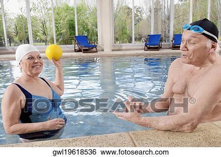 Couple playing in a swimming pool View Large Photo Image Stock Photograph - Couple playing in a swimming pool. Fotosearch