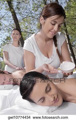 Couple receiving back massage from massage therapists View Large Photo Image Picture - Couple receiving back massage from massage therapists. Fotosearch