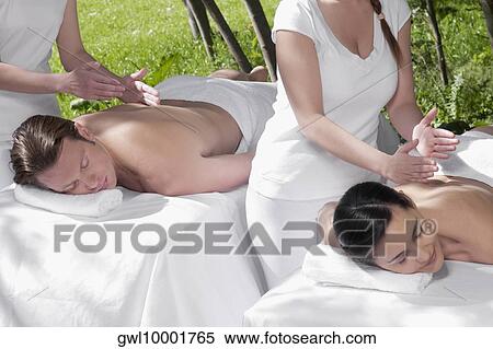 Couple receiving back massage from massage therapists View Large Photo Image Stock Photography - Couple receiving back massage from massage therapists. Fotosearch
