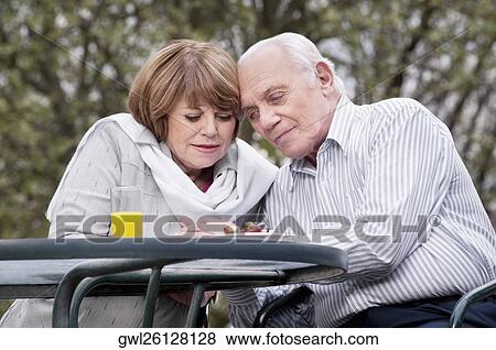 Couple sitting at a table and thinking View Large Photo Image Stock Photo - Couple sitting at a table and thinking. Fotosearch
