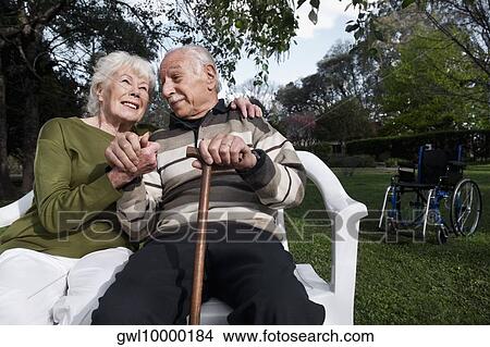 Couple sitting in a park View Large Photo Image Picture - Couple sitting in a park. Fotosearch