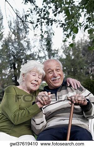 Couple sitting in a park View Large Photo Image Stock Image - Couple sitting in a park. Fotosearch