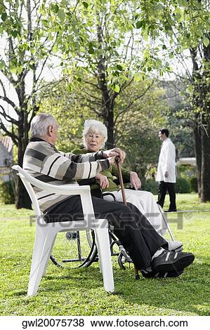 Stock Photo - Couple sitting in a park. Fotosearch