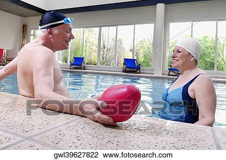 Couple smiling in a swimming pool View Large Photo Image Stock Image - Couple smiling in a swimming pool. Fotosearch