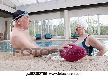 Couple smiling in a swimming pool View Large Photo Image Stock Photography - Couple smiling in a swimming pool. Fotosearch